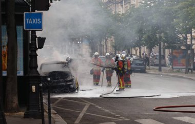 PARIS, FRANCE - 23 Mayıs 2020: Paris sokaklarında kaza. İtfaiyecilerden bazıları yangını söndürüyor. Paris 'teki Zafer Kemeri' nin yakınındaki arabayı..