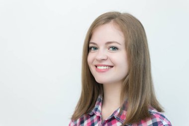 Gülümseyen, güzel, beyaz, çiçekli tişörtlü bir kızın portresi.