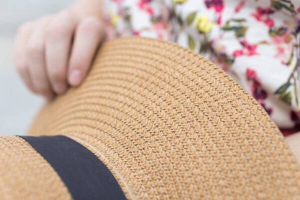 Закройте макро женской руки с соломенной шляпой
