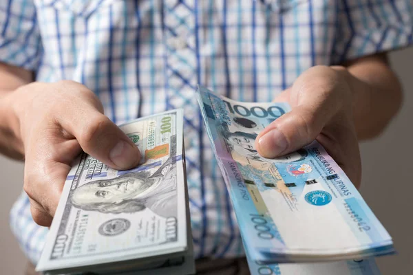 El ele tutuşup 1000 Filipin pesosu ve Amerikan doları veriyoruz. Para değişimi