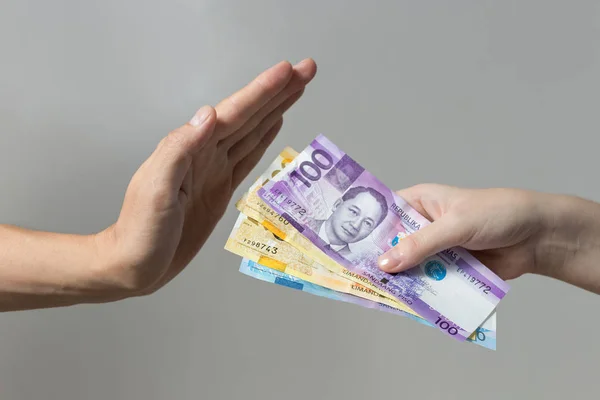 Hand holding giving cash banknotes Philippines peso paying bills, payment procedure or bribe, salary