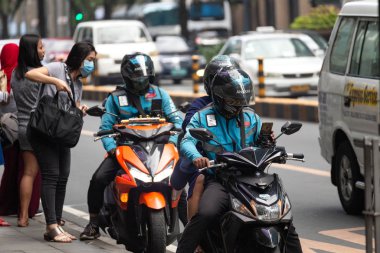 Manila, Philippines - February, 3, 2020: Motorcyclist commute in traffic on the roads of Makati