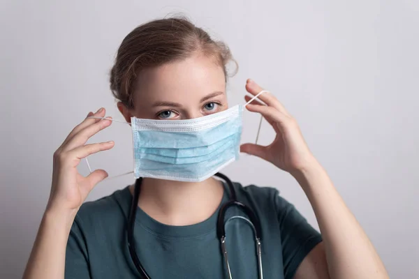 Cerrahi maske takan beyaz kadın doktor hemşire.