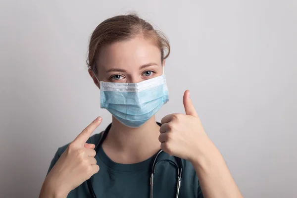 Cerrahi maske takan beyaz kadın doktor hemşire.