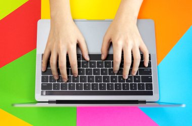 Dizüstü bilgisayar klavyesinin üst görüntüsü, renkli arkaplan. İş yeri, internet kavramı