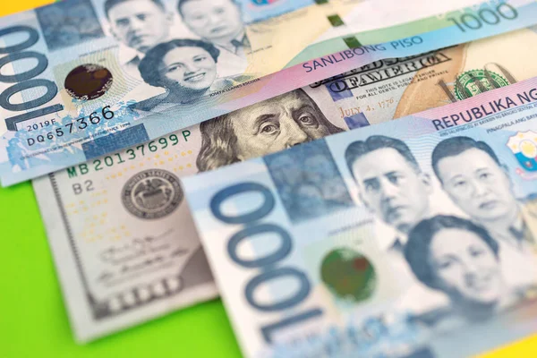 1000 Filipinli pezosu ve Amerikan dolarının nakit banknotunu kapat.