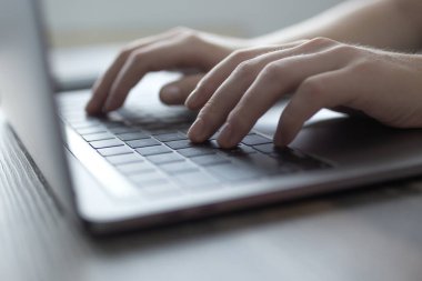 Eller gümüş dizüstü bilgisayar klavyesinde yazarken, kapat