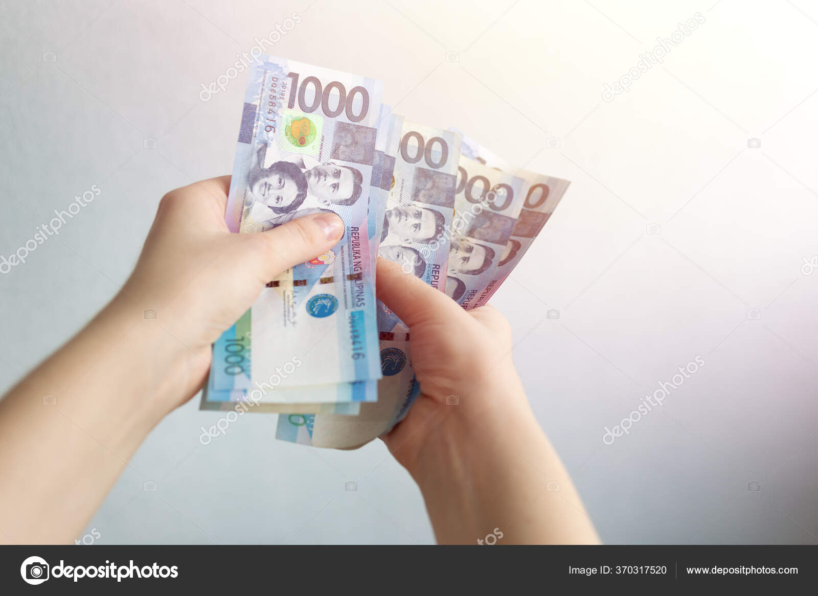 持有1 000菲律宾比索现钞的人支付账单付款或薪金白色背景——图库图片© aldarinho #370317520