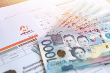 Manila, Filipinler - 6 Mayıs 2020 Meralco fatura kağıdında 1000 Filipinli peso nakit para. Fatura ödeme konsepti, kapat..