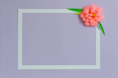 Pastel mor arkaplanda pembe renkli kağıt çiçekli dikdörtgen çerçeve. Düz yat, boşluğu kopyala