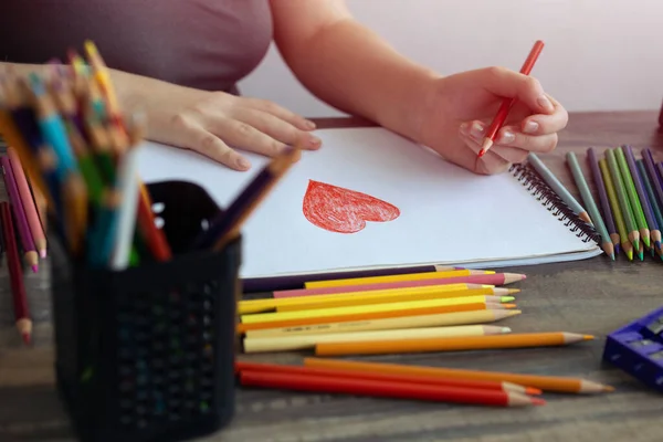 手を閉じて白い紙に色鉛筆で心を描く アートスタジオワークプレイスのコンセプト ストック写真
