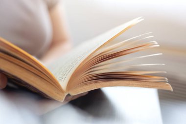 Sarı sayfaları olan eski, açık bir kitabın eski bir kopyası. Hırslı okuyucu, kitap kurdu konsepti