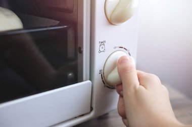 Mikrodalga fırının zamanlayıcısını elle çevirmenin arka planını kapat. Ev yemeği ya da yemek hazırlama konsepti