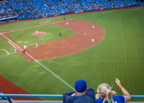 Erkek ve kadın bir beyzbol oyunu açılış sahada izlerken — Stok fotoğraf