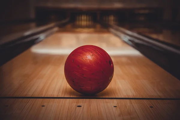 Bola roja de bolos en la pista en el centro de bolos — Foto de Stock