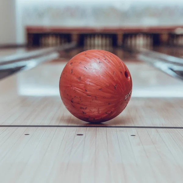 Bola roja de bolos en la pista en el centro de bolos — Foto de Stock