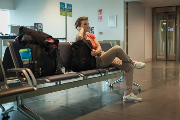 Young woman with luggage waiting in the airport hall her plane — Stock Photo, Image