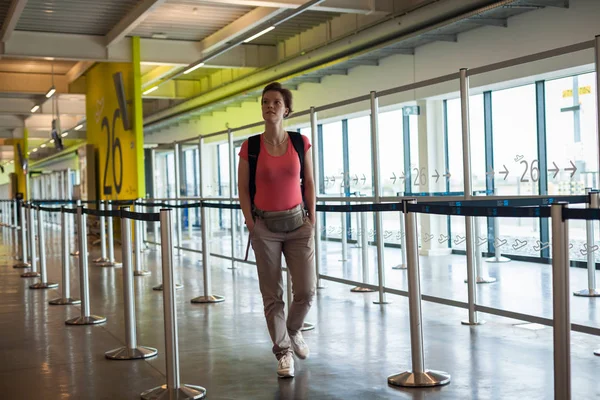 Jeune femme avec des bagages attendant dans le hall de l'aéroport son avion — Photo