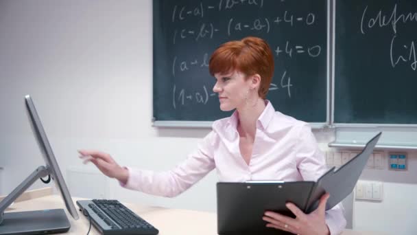 Young teacher lectures at the School of Mathematics, writes chalk on a blackboard — Stock Video