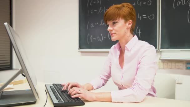 Junge Lehrerin unterrichtet an der Schule für Mathematik, schreibt Kreide auf eine Tafel — Stockvideo