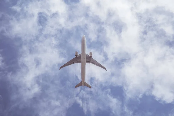 Avião no céu azul com nuvens. Viaje pelo mundo no ar — Fotografia de Stock