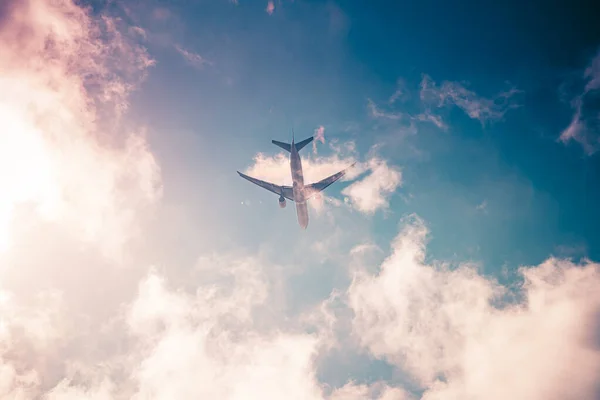Самолет на голубом небе с облаками. Путешествие по миру в воздухе — стоковое фото