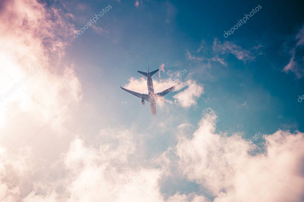 Airplane on blue sky with clouds. Travel around the world in the air