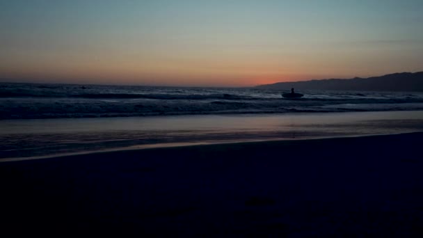 Закат на Тихоокеанском побережье в Калифорнии, серфер и бегуны бегают спорт — стоковое видео