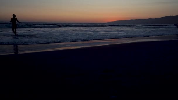 Solnedgang på stillehavskysten i California, surfer og joggere driver en sport – stockvideo