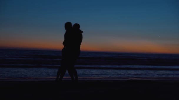 Happy loving couple on shore ocean at sunset in summer — Stock Video