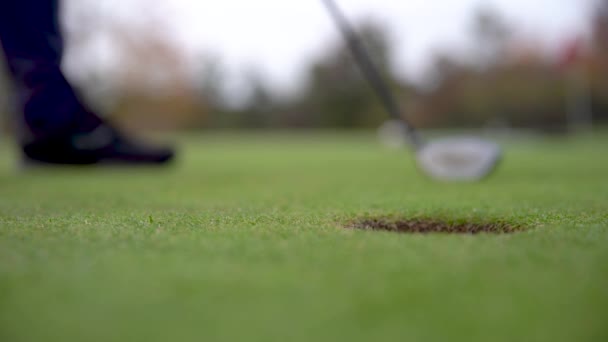 Игрок в гольф готовит мяч к выстрелу на поле для гольфа — стоковое видео