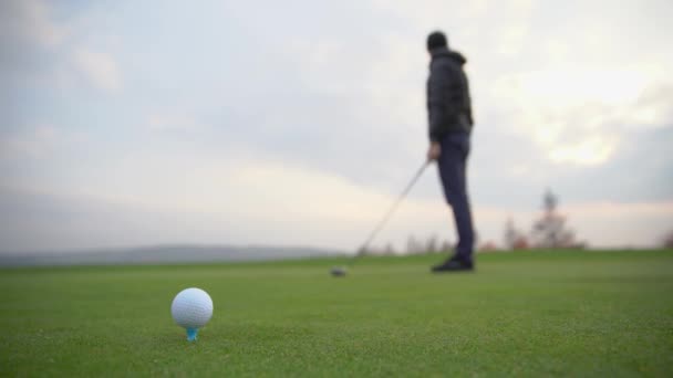 Um jogador de golfe prepara a bola para ser disparado no campo de golfe — Vídeo de Stock