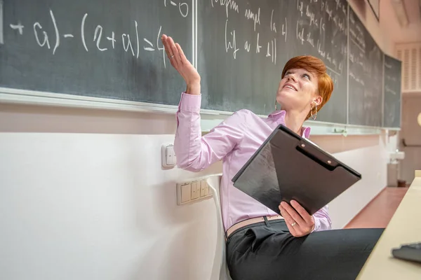 Unga lärare föreläser på Matematikhögskolan, skriver krita på svarta tavlan — Stockfoto