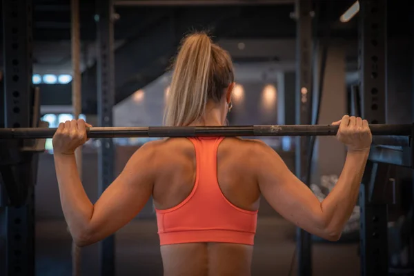 Una joven con figura deportiva practicando en el gimnasio, fitness y musculación — Foto de Stock