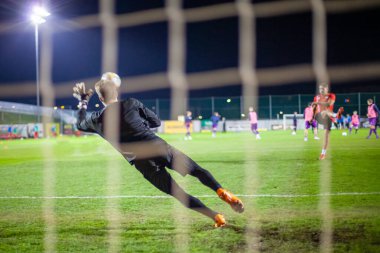 Kaleci bir futbol maçında defansta topu yakaladı.