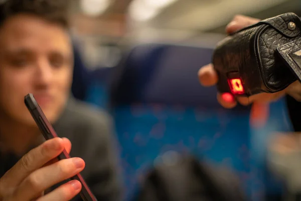 Joven simpático hombre muestra un conductor de billete electrónico en el tren en su teléfono inteligente. Comprobación por dispositivo de lectura — Foto de Stock