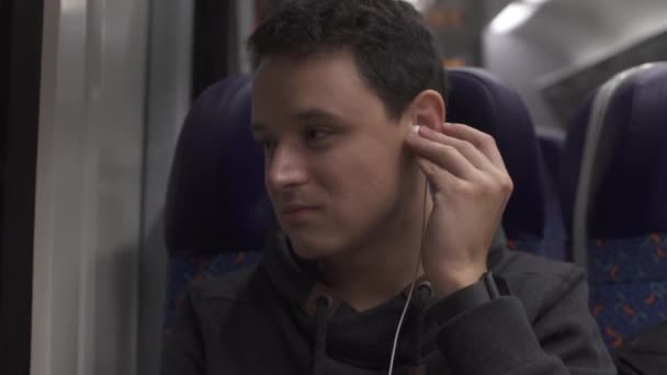 기차에서 일하고 스마트폰으로 즐겁게 놀고 음악을 제공하는 젊은이 — 비디오