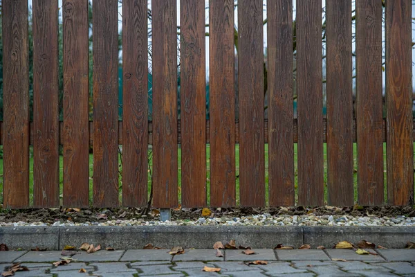 Деревянный забор перед зеленым садом семейного дома — стоковое фото