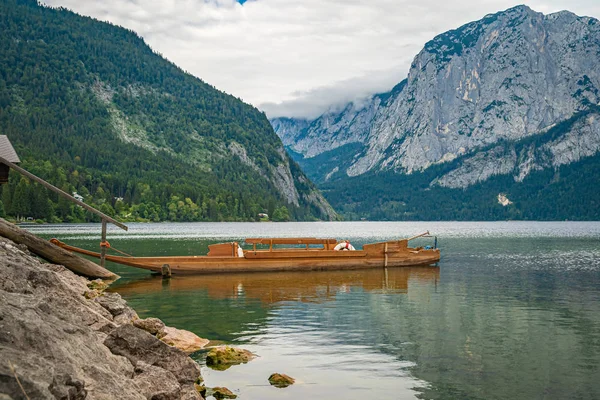 Βάρκες σε μια βουνίσια λίμνη έτοιμες να δανείσουν τουρίστες για κολύμπι στη γαλάζια επιφάνεια του νερού — Φωτογραφία Αρχείου