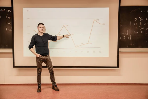 Student som visar en graf på en projektionstavla medan han undervisar i skolan — Stockfoto