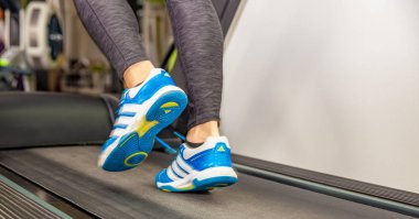 Olomouc, Çek Cumhuriyeti - 25 Ekim 2018: Koşu bandındaki mavi Adidas marka ayakkabılı kadın
