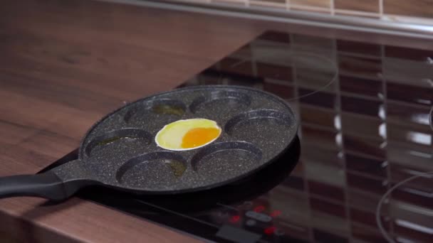 Eier in einer Pfanne in der Küche zubereiten. Frühstück für die ganze Familie — Stockvideo