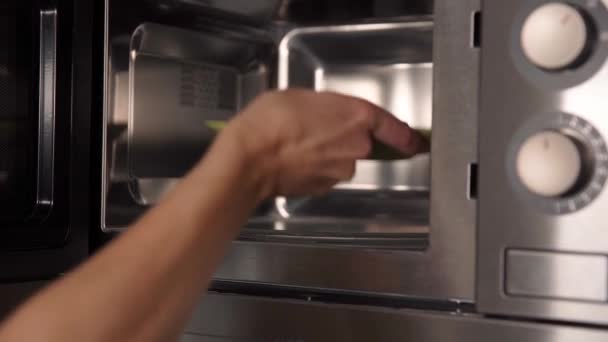 Ogrzewanie żywności w kuchence mikrofalowej w kuchni w domu — Wideo stockowe