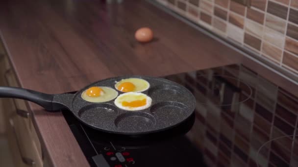 Eier in einer Pfanne in der Küche zubereiten. Frühstück für die ganze Familie — Stockvideo
