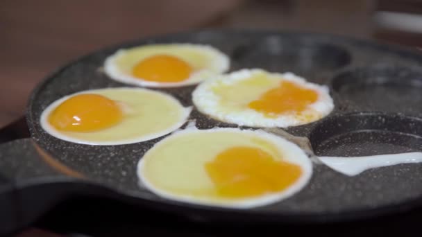 Preparing eggs in a pan in the kitchen. breakfast for the whole family — ストック動画