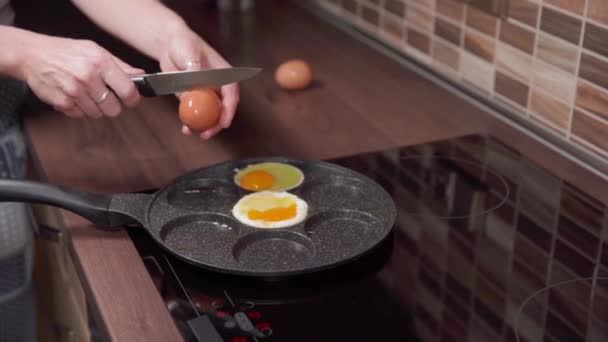 Preparing eggs in a pan in the kitchen. breakfast for the whole family — ストック動画