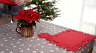 Noel tatili için şenlik masası. Noel yıldızları ve kırmızı yer minderlerinin hazırlanması