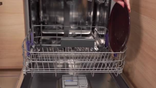 Dirty plates are stacked in the dishwasher in the kitchen — ストック動画