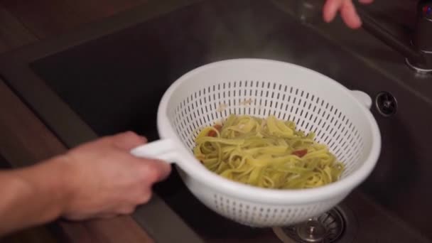 Zeven van de bereide pasta en vervolgens spoelen met vloeibaar water — Stockvideo