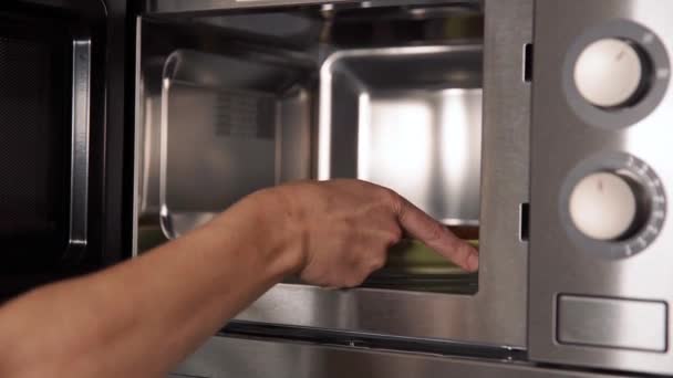 Θέρμανση τροφίμων σε φούρνο μικροκυμάτων στην κουζίνα στο σπίτι — Αρχείο Βίντεο